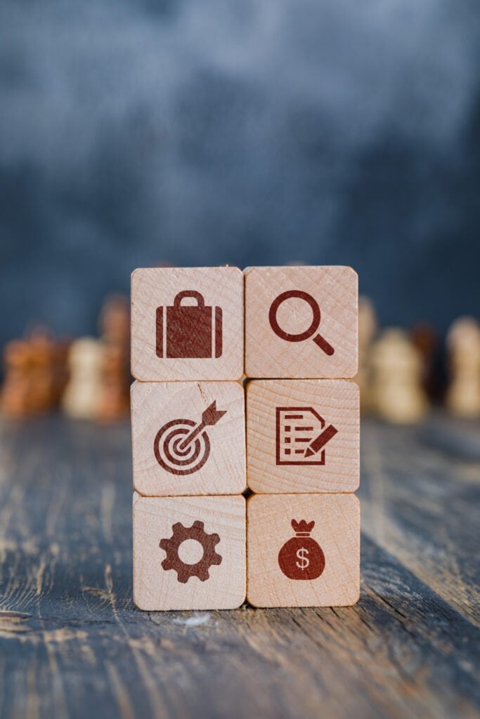 Wooden blocks with business strategy icons stacked